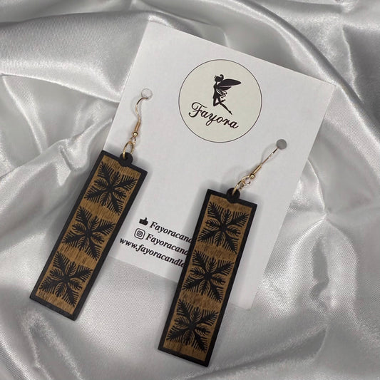 Wooden earrings with floral patterns on a white card with 'Fayora' branding, set against a satin background.